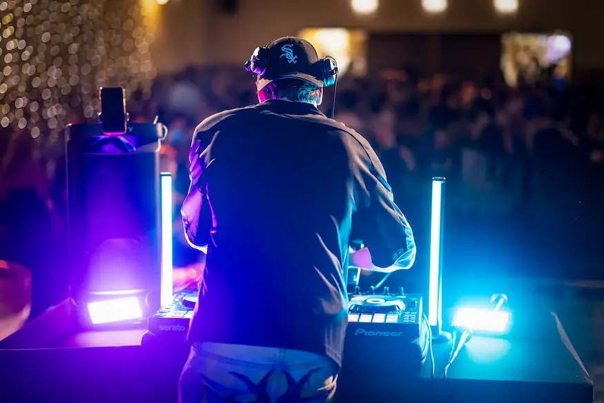 AI-generovaný obrázek DJe mixujícího hudbu v klubu s barevnými světly.